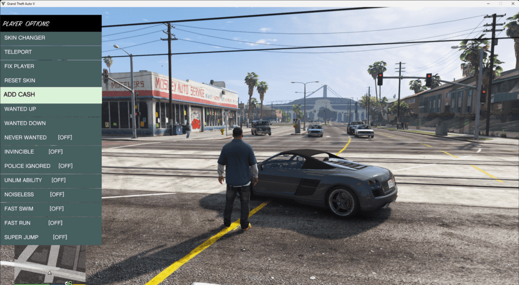 n-game screenshot of GTA 5 showing the Native Trainer menu open on the left side of the screen. The player character stands in the middle of an intersection near a parked sports car. The trainer menu displays various options, including 'ADD CASH,' 'INVINCIBLE,' and 'SUPER JUMP,' allowing modifications to gameplay.